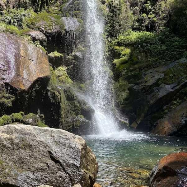 The waterfall at Barshangarh dropping over dark rocks into a forest pool