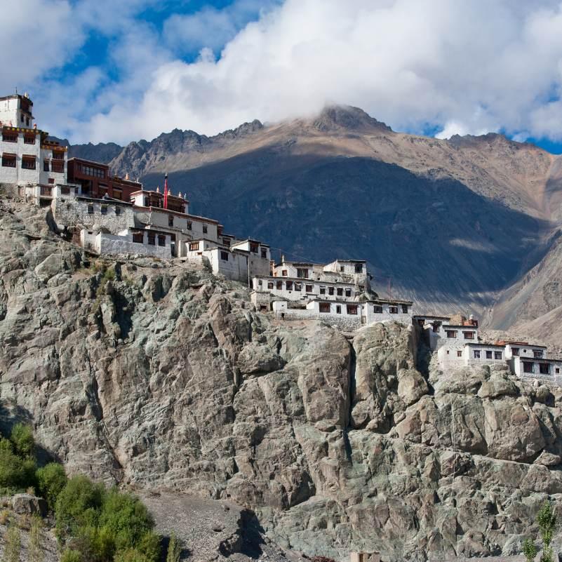 Diskit Monastery lit by late afternoon sun, with the dry mountain ridges of the Ladakh Range behind