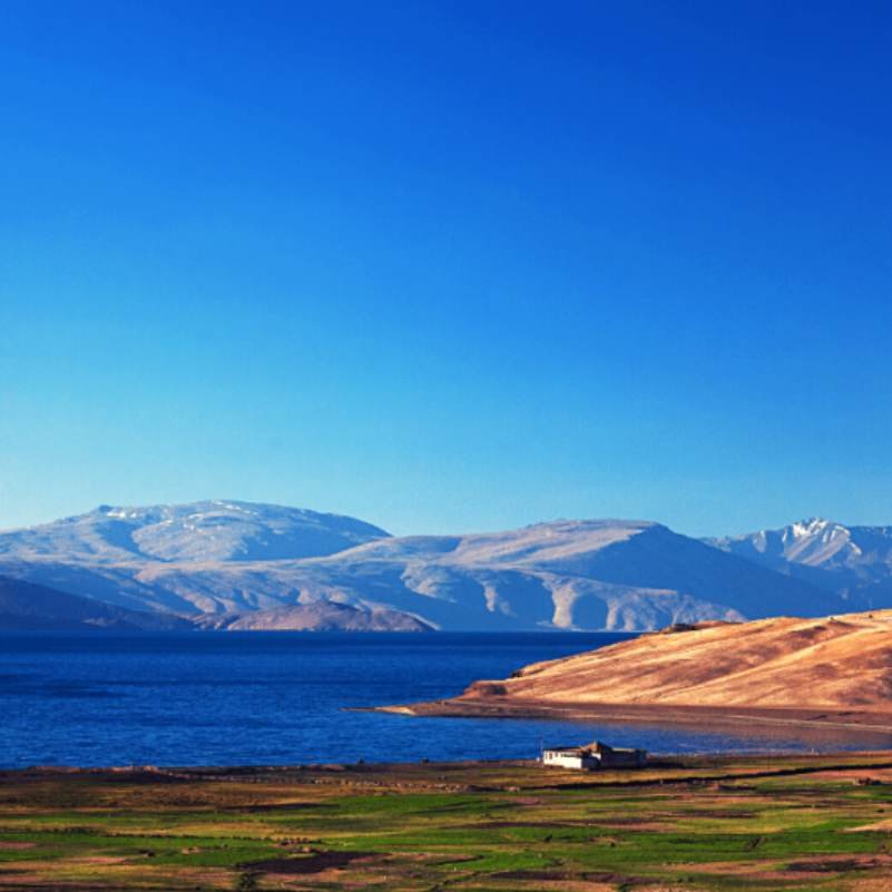 Turquoise waters of Tso Moriri Lake stretching between dry hills on the Changthang plateau, the signature wide view most travellers come for