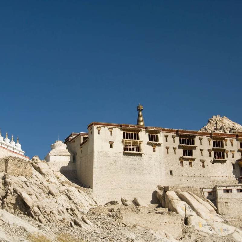 Sunlit Shey Palace with the mountains of the Indus valley behind, late afternoon light on the old walls