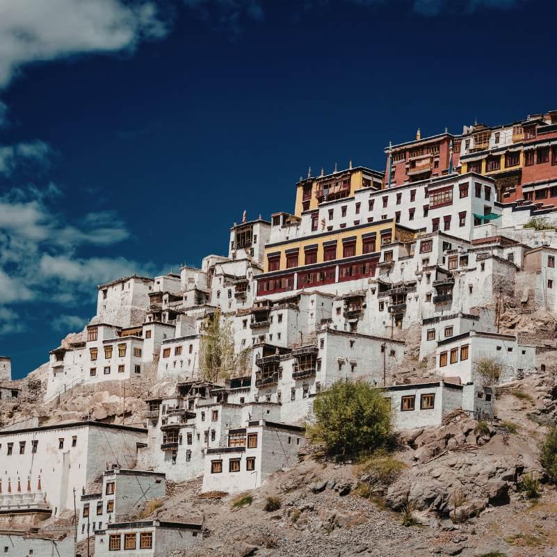 Thiksey Monastery rising above the flat Indus valley plain with the Ladakh range behind