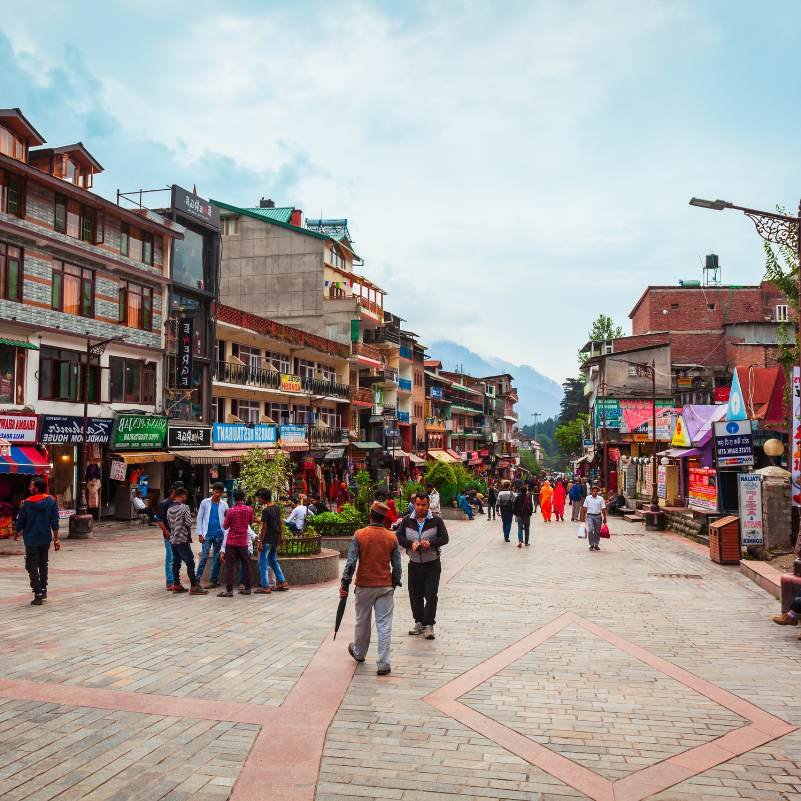 Mall Road Manali with tourists walking past shops and restaurants