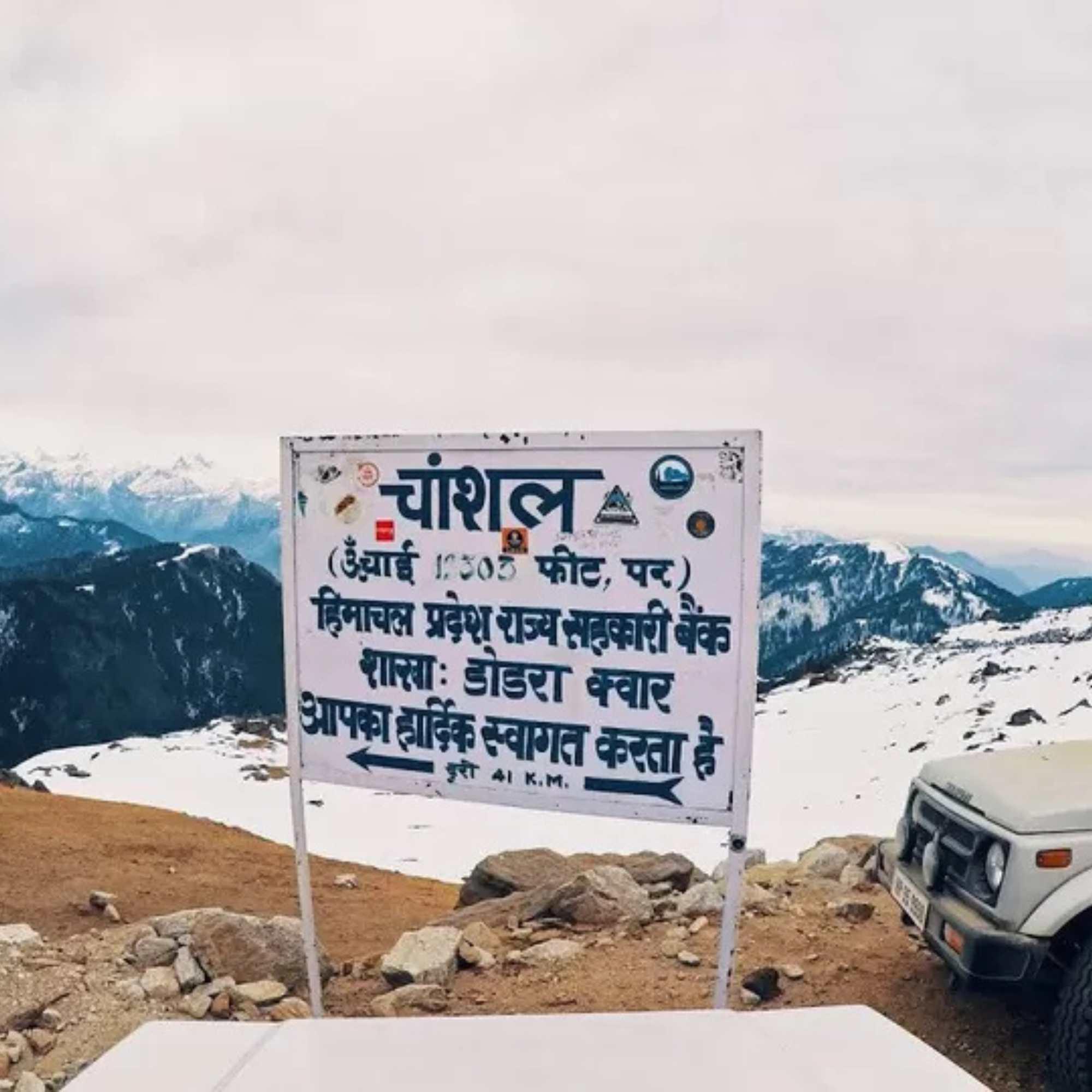Snowy road leading to Chanshal Pass during a scenic Himachal mountain journey.jpg