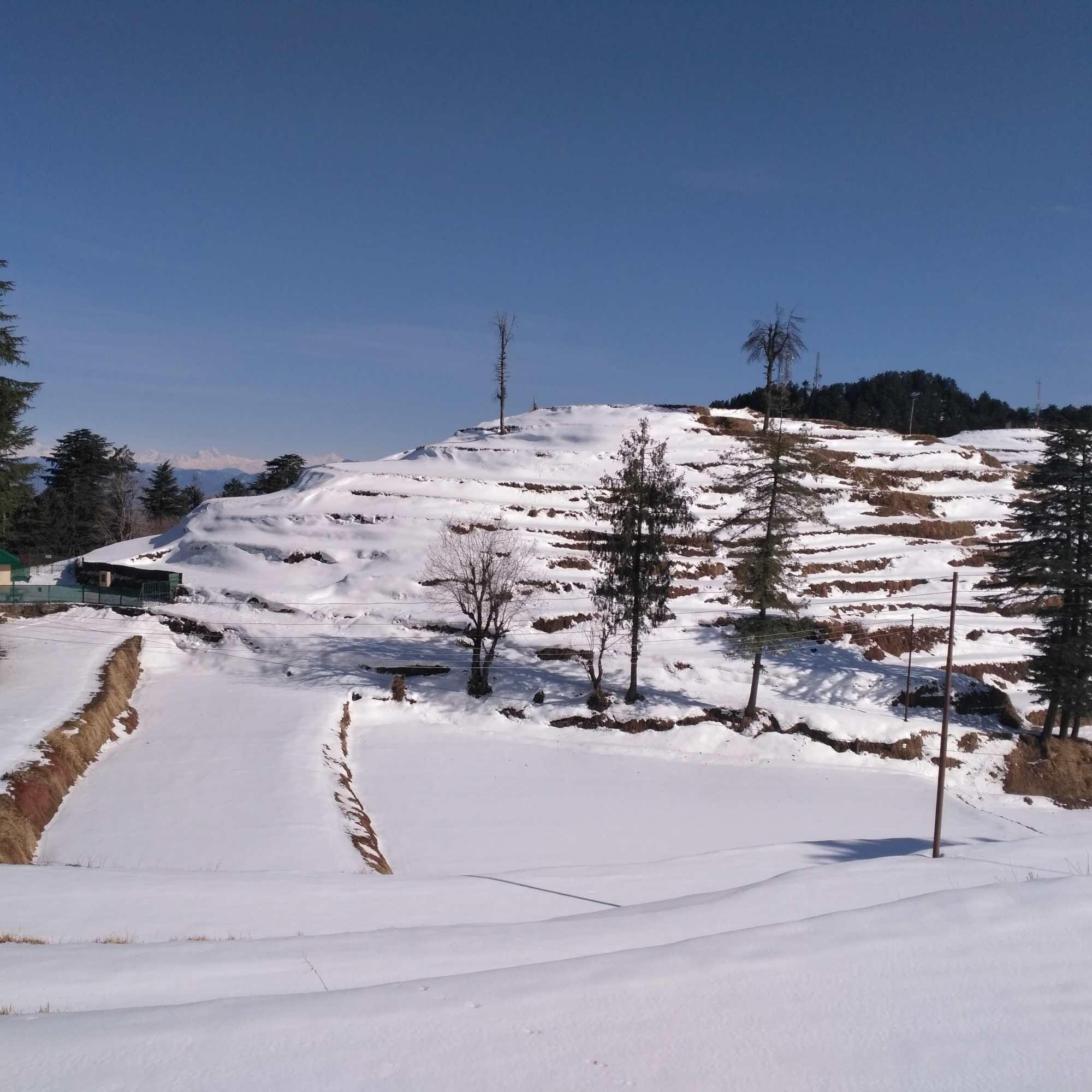 Kufri covered in snow during winter with surrounding hills