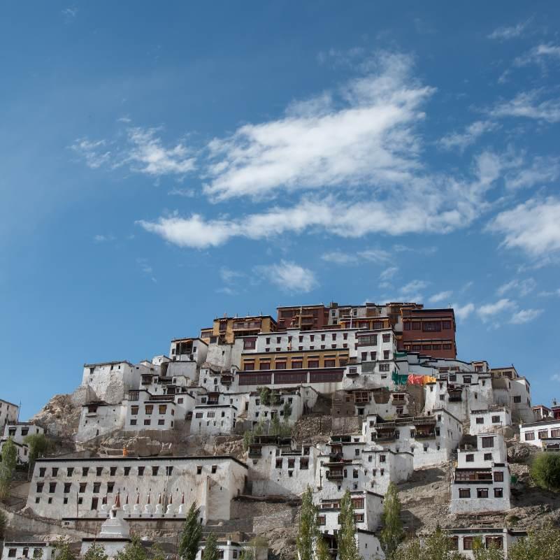 Hilltop view of Thiksey Monastery with the snow capped mountain backdrop of the Stok range